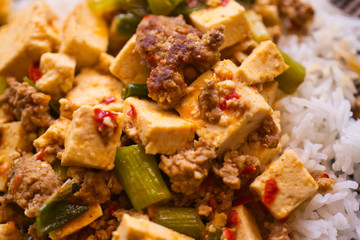 Mapo Doufu also known as Mapu Tofu, a spicy Asian dish made from minced meat and tofu cubes with spring onions and lots of chili, close up