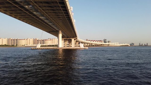 Panorama of the Neva River at sunset. View from the ship. Passenger person looks at the bridge.