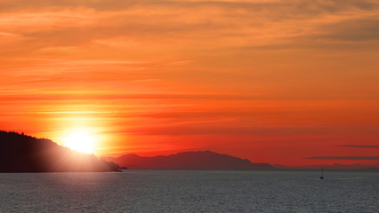 Orange sunset and mountains silhouette on Pacific Ocean. British Columbia. Canada 