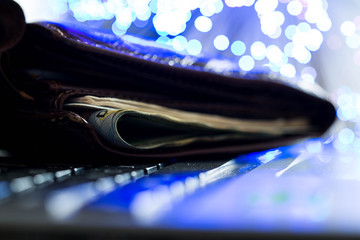Glowing high speed internet optical fibres, opened wallet on computer keyboard,  focus on the...