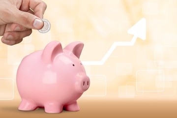 Man putting coin in pig moneybox