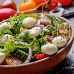 Vegetable salad with mozzarella cheese, lettuce, cherry tomatoes, radish, cucumber, onion and basil...