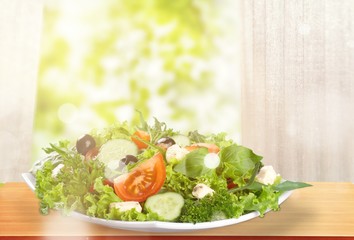 Individual side serving of delicious fresh Greek salad with feta cheese, olives, tomatoes and salad greens