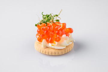 Canape portion cracker, butter, salmon red caviar. Beautifully decorated catering banquet menu. Food snacks and appetizers for buffet. Isolated on white background