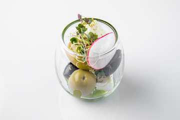 Olives in a glass. Beautifully decorated catering banquet menu. Food snacks and appetizers for buffet. Isolated on white background