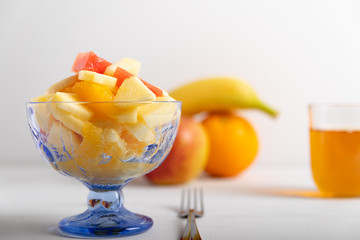freshly made fruit salad in a blue bowl on a white background