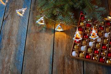  Electric garland, Christmas balls and fir tree on a wooden table.