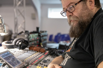Sound engineer behind the sound mixing console controls the sound. Digital and analog sound mixer.  Sound setting
