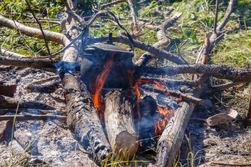 teapot on the fire, Boiling water with a kettle on the fire at an outdoor campsite.