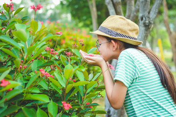 Asian children wear hats that are happy to see flowers.