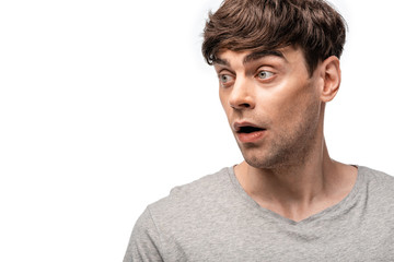 Obraz premium shocked young man looking away isolated on white with copy space