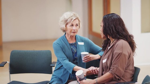 Two Women Talking After Meeting In Community Center