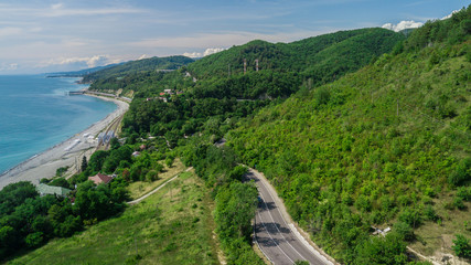 Fototapeta na wymiar Aerial view - curvy road of mountain road to Sochi, Russia. Great road trip trough the dense woods.