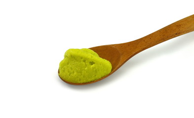 Puddle of green wasabi dressing or wasabi sauce in a wooden spoon isolated on white background.