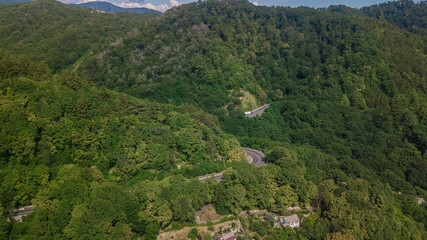 Aerial view - curvy road of mountain road to Sochi, Russia. Great road trip trough the dense woods.