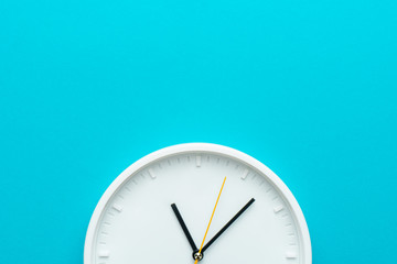 Part of white wall clock with yellow second hand hanging on wall. Close up image of plastic wall...