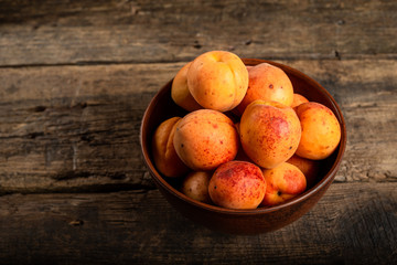 fresh apricots in a basket on a wooden table