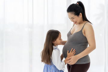 daughter touching belly of pregnant mother's.