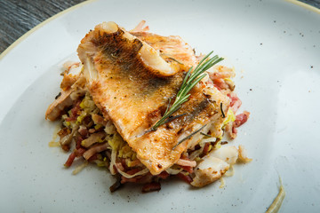 closeup two grilled fish pieces served on meat salad