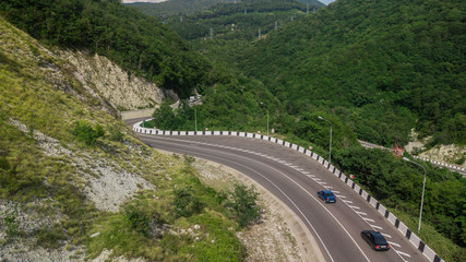 Birds Eye View - winding road from the high mountain pass in Sochi, Russia. Great road trip trough the dense woods.