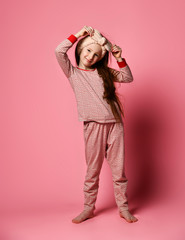 Full-length portrait of winsome girl in her pink pajamas and a soft headband is painted in the frame.