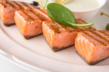 Grilled fish fillet salmon. Selected pieces of red fish. Seafood. Banquet festive dishes. Fine dining restaurant menu. White background.