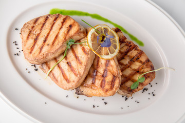 Grilled salmon fish fillet (red fish). Seafood. Banquet festive dishes. Fine dining restaurant menu. White background.