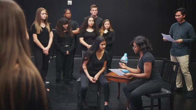 Teacher With Drama Students At Performing Arts School In Studio Improvisation Class