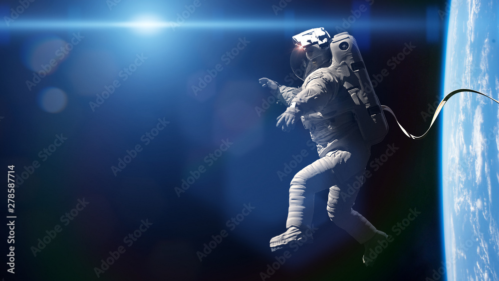 Wall mural astronaut performing a spacewalk in orbit of planet earth