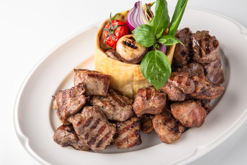 Skewers of pork, beef with vegetables and mushrooms. Grilled meat. Banquet festive dishes. Fine dining restaurant menu. White background. 