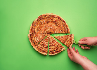 Woman hand cutting an apple pie. Home-baked sweets