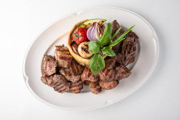 Skewers of pork, beef with vegetables and mushrooms. Grilled meat. Banquet festive dishes. Fine dining restaurant menu. White background. 