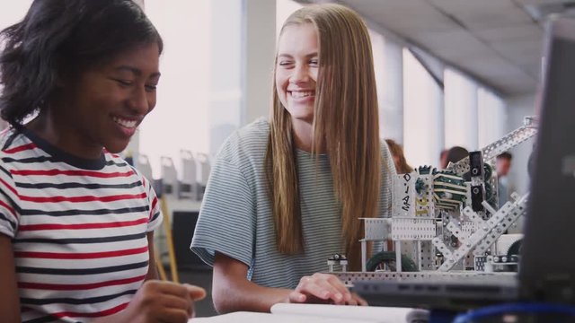 Two Female College Students Building Machine In Science Robotics Or Engineering Class