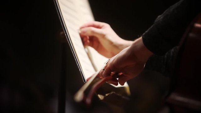 Close up shot of a musician writing notes on a music sheet.