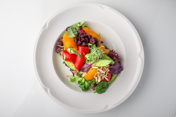 Salad of grilled vegetables in combination with fresh vegetables, cheese and sprouts of micro greens. Nutritious healthy dish. Banquet festive dishes. Gourmet restaurant menu. White background.
