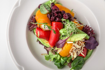 Salad of grilled vegetables in combination with fresh vegetables, cheese and sprouts of micro greens. Nutritious healthy dish. Banquet festive dishes. Gourmet restaurant menu. White background.