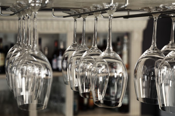 Set of empty clean glasses on bar racks