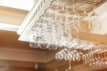 Set of empty clean glasses on bar racks