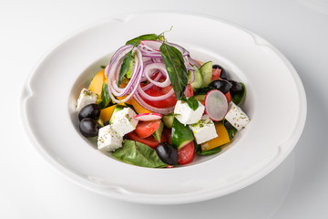 Traditional Greek salad with fresh vegetables, olives and cheese. Nutritious healthy dish. Banquet festive dishes. Gourmet restaurant menu. White background.