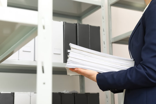 Female worker with documents in office, closeup