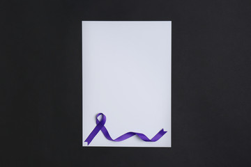 Purple awareness ribbon and blank card on black background, top view with space for text