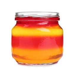 Tasty layered jelly dessert in glass jar on white background