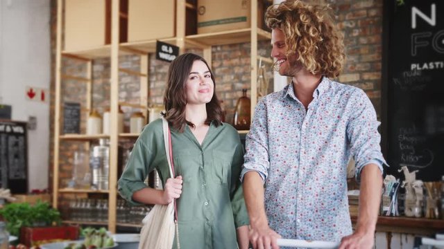 Portrait Of Young Couple Shopping In Sustainable Plastic Free Grocery Store