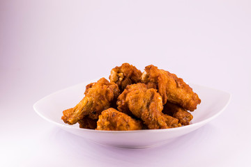 A white plate with fresh, crispy fried chicken