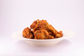 A white plate with fresh, crispy fried chicken