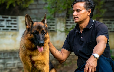 German Shepherd with Handler in Garden