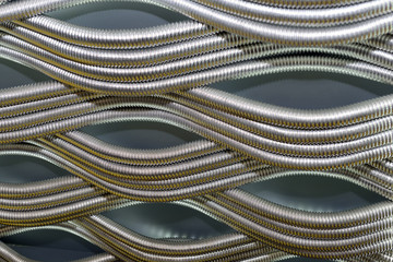 Corrugated stainless metal tubes for water supply. Abstract industrial background.