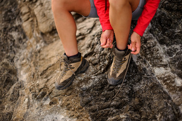 Close shot of female hiker tiyng up shoelaces