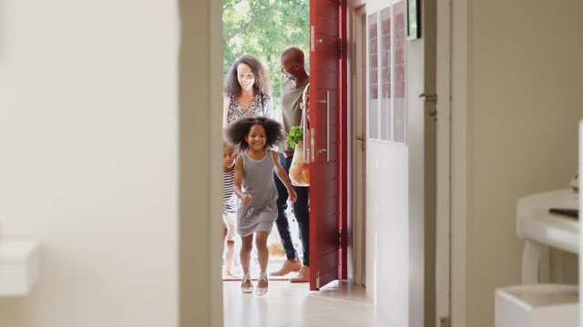 Family Returning Home From Shopping Trip Using Plastic Free Grocery Bags Opening Front Door