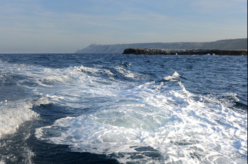 In swimming on a small boat to the sea foam and salt spray you can reach out by hand. В дымке...